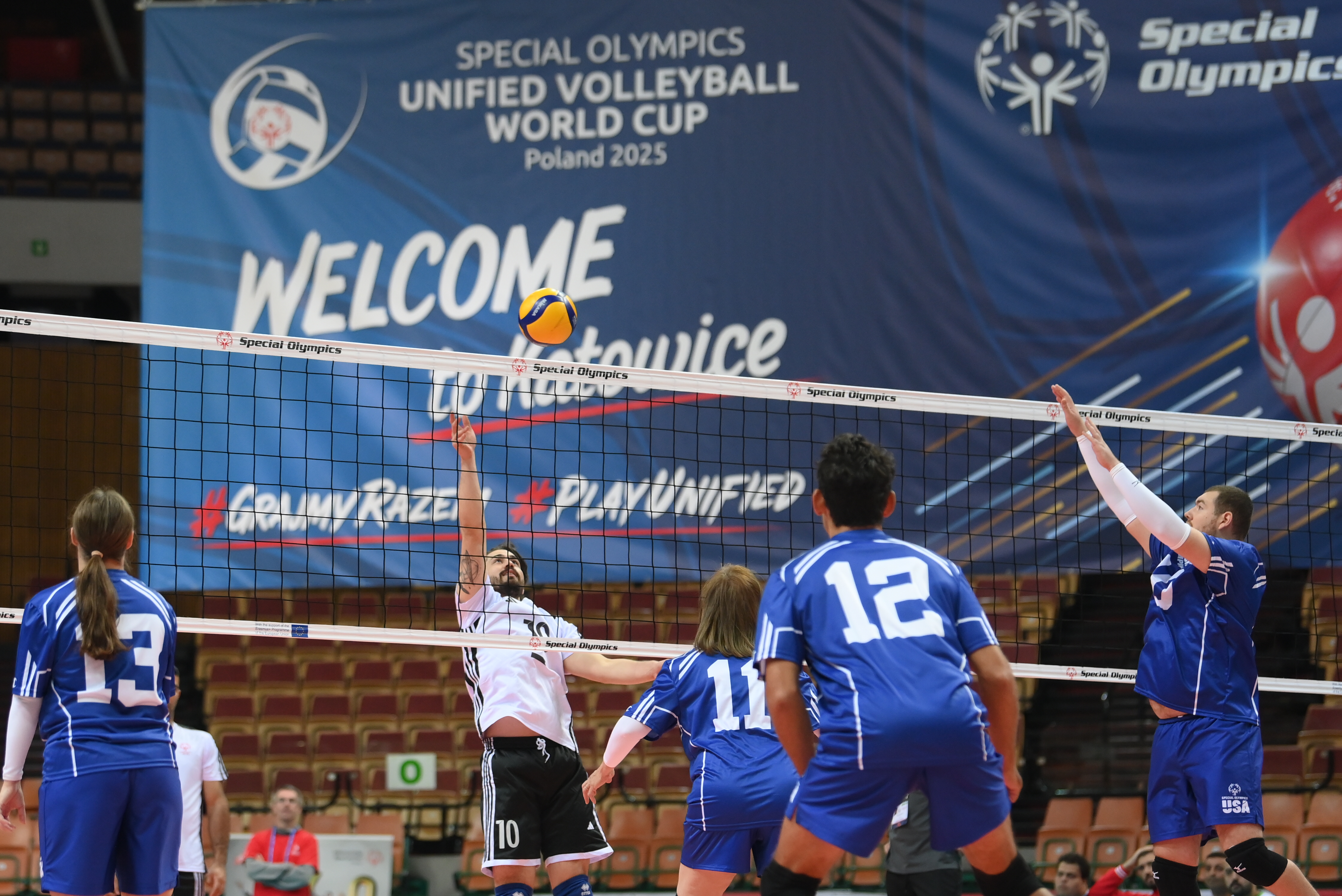 Unified volleyball match, a player rises to block
