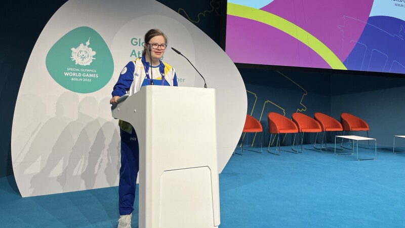 Atleta de pie en un podio hablando.