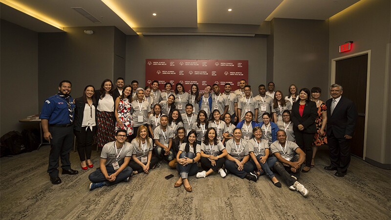 Large group of people in a room sitting for a group photo.