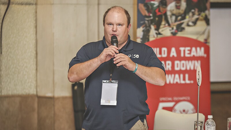 Ben Haack speaks with a microphone.