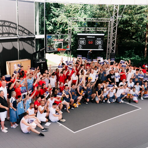 A large group of athletes gather together on a basketball court. 