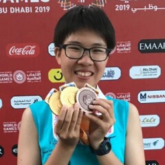 Yi-Hsuan Tseng holding up two gold and one bronze medal.