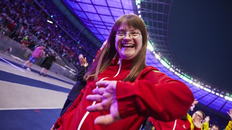The Special Olympics athlete smiles and waves to the camera