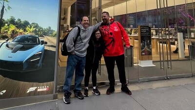 Three people standing in front of the Microsoft building. 