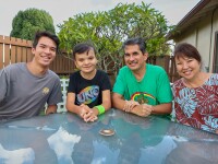 A family of four take a group photo. 