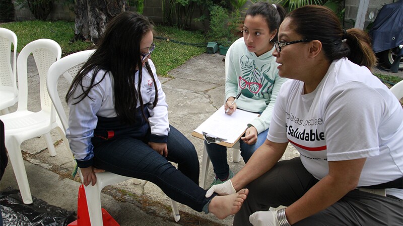 Profesionales de la salud voluntarios de Atletas Saludables atienden a atletas de Olimpiadas Especiales durante las revisiones médicas gratuitas.