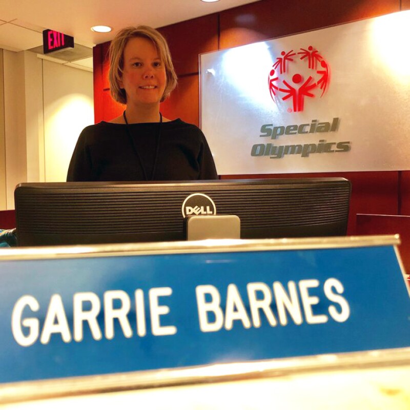Garrie Barns at Special Olympics standing behind the receptionists desk.