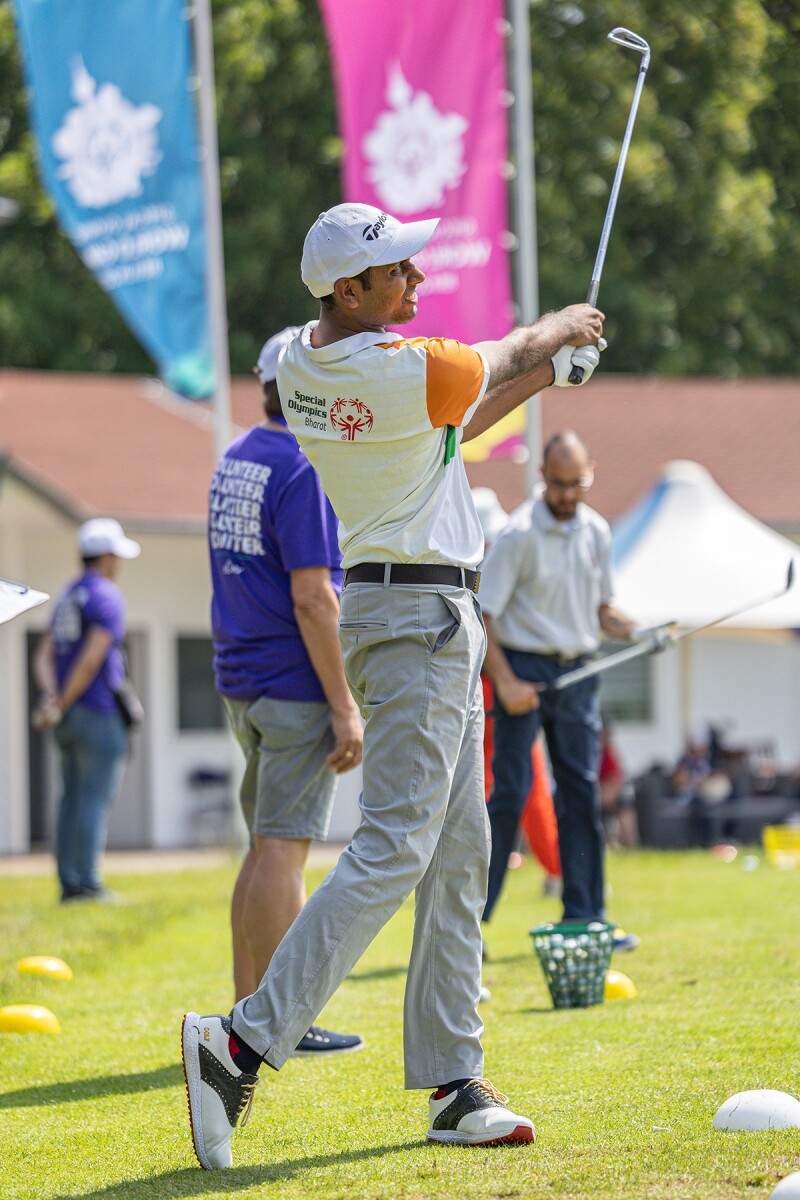 Man standing post-swinging a golf club