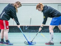 Two female floorball players facing each other on the field