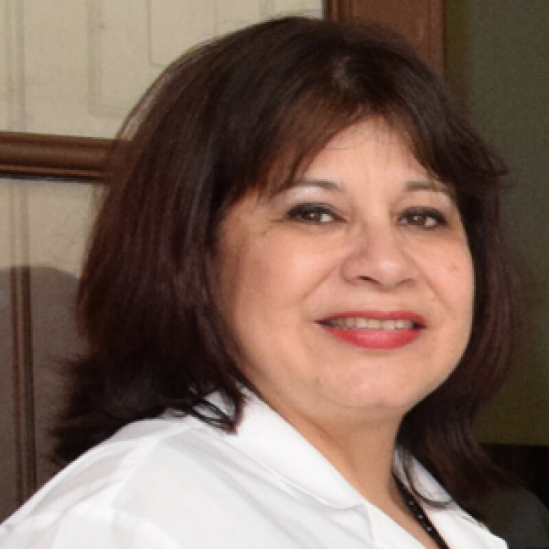 Dr. Ferreira smiling in a white lab coat