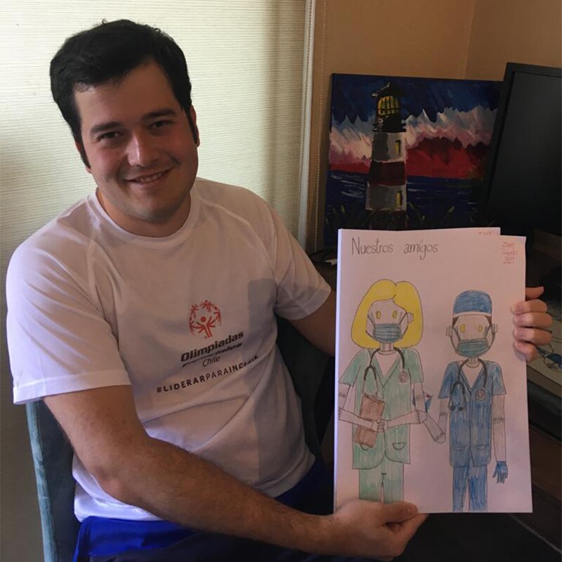 Isaac González posa con una de sus obras, un dibujo de doctores robots.