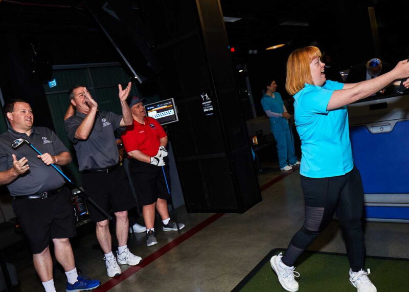 Woman hitting a ball with a golf club. 