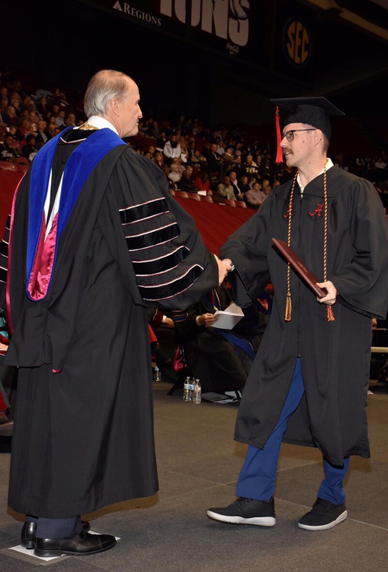 RJ graduating on stage receiving his diploma.