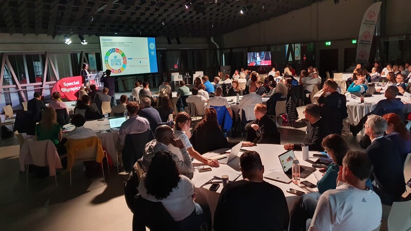 people sitting at tables listening to a presentation