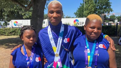 Three athletes standing side by side for a group photo. 
