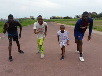Four young men preparing to race down a track. 