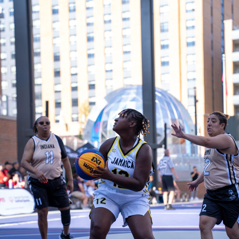 Young woman sets up to shoot the ball. 