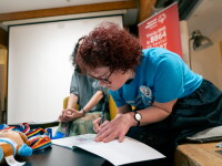 A woman signs an open book. 
