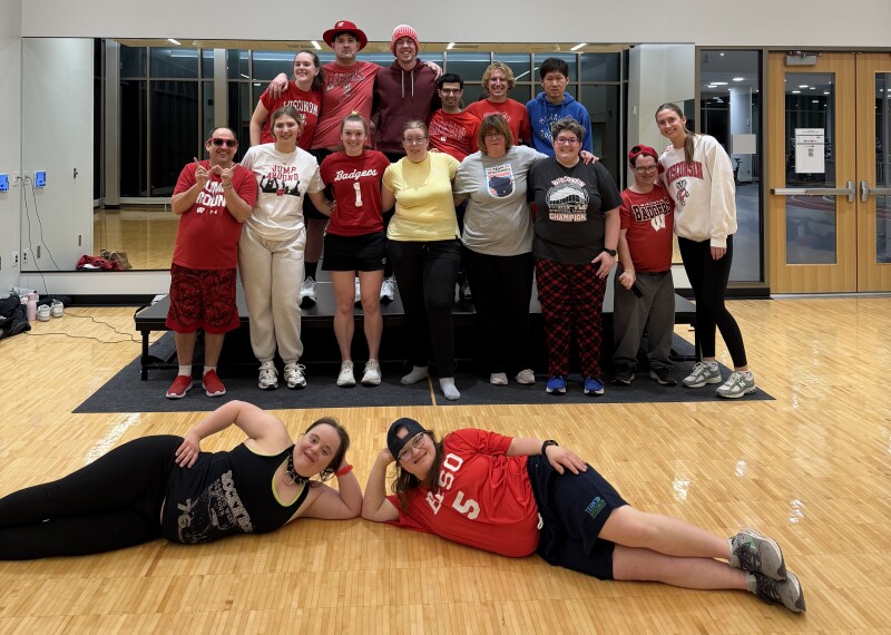 A large group photo showing athletes posing for a photo at the end of a fitness class.