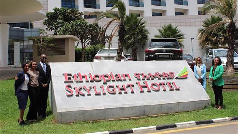 Individuals standing next to Ethiopian Airlines Skylight Hotel sign