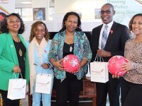 five people standing holding draw-string bags and Special Olympic soccer balls