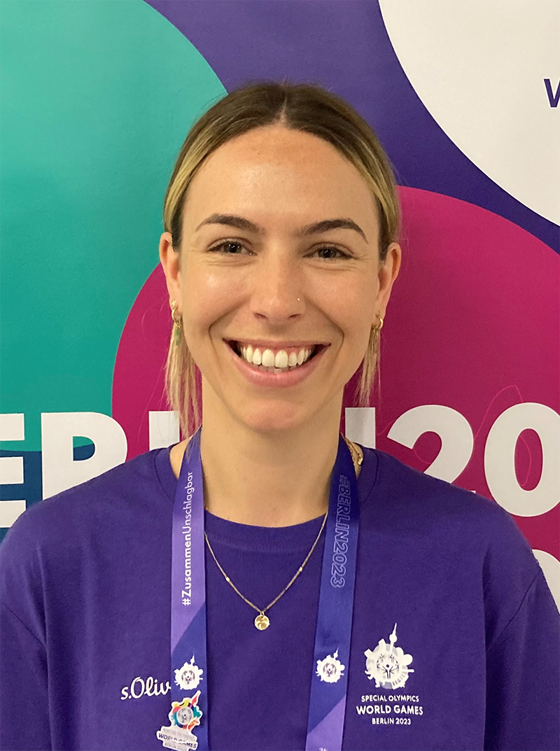 Emily poses for the camera wearing a purple shirts that the Games volunteers have been assigned.