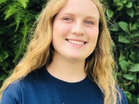 Elyssa Seelig standing outside wearing an EPSN and Special Olympics Unified Sports blue t-shirt. 