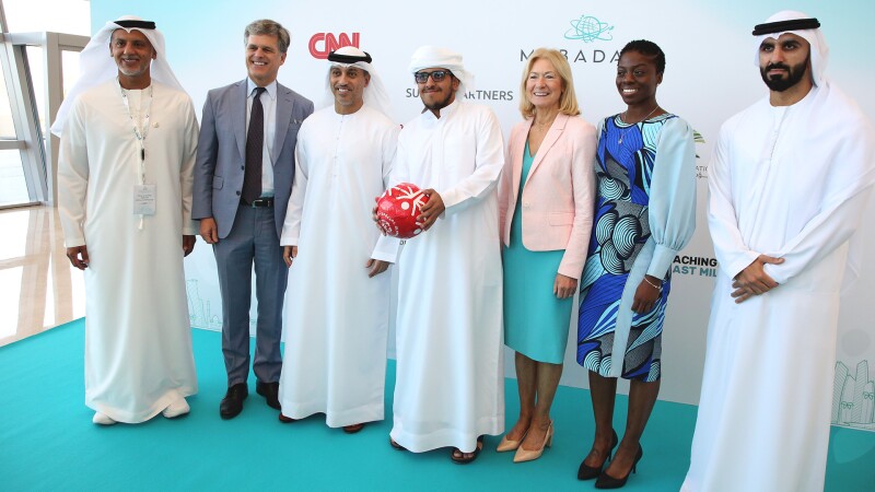 A group of people standing in front of signage.