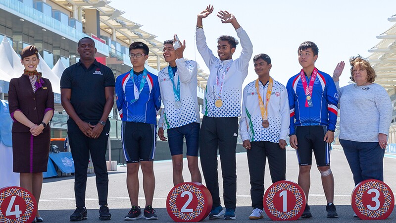 8 people, from the left, one Ethiad representative, a male trainer, 5 athletes including Abhishek with a bandage on his hand and another trainer.