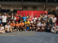 Large group photo in a gymnasium setting, a Special Olympics Unified Football World Cup Paris 2026 banner is behind the group. 