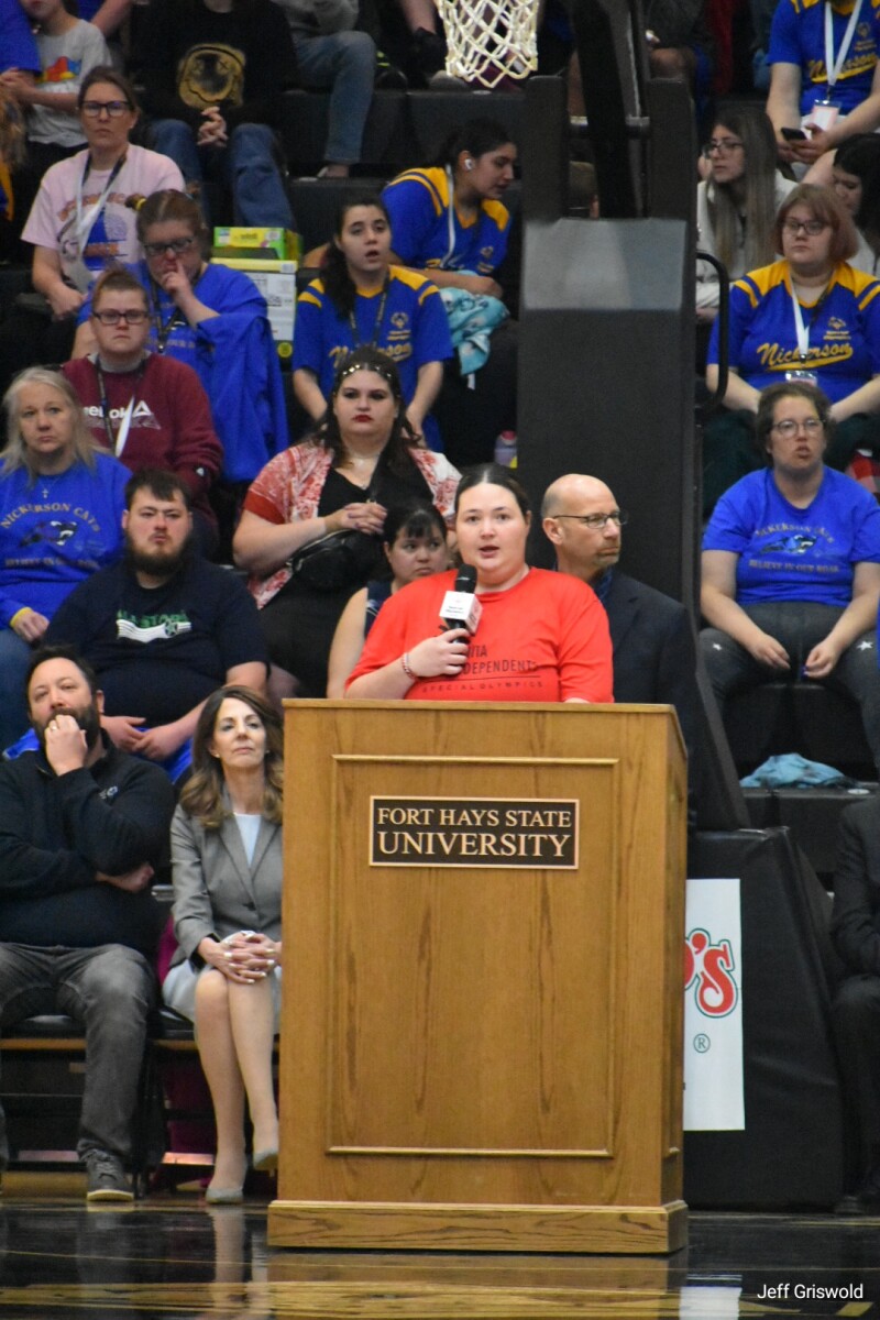 young woman standing at a podium speaking. 
