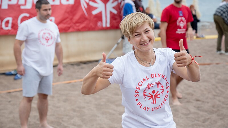 Adults on the beach playing volleyball.