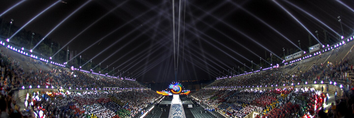 2011 World Game Opening Ceremony at night with bleachers full and a light show in the sky. 