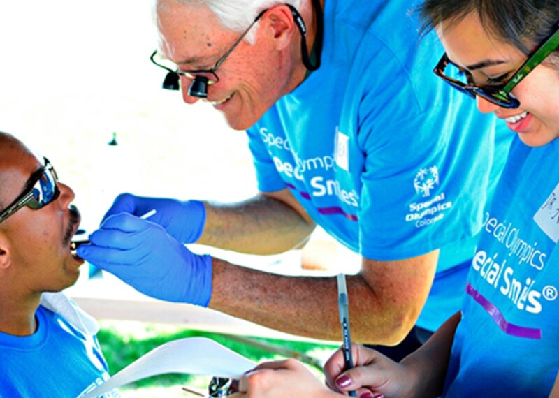 Athlete receiving a dental examination and an assistant takes notes. 