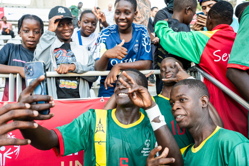 Two Special Olympics Senegal players posing with fans in the Stands