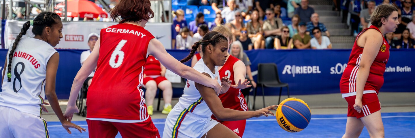 A 3x3 group of young women playing basketball