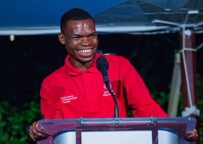 Nyasha standing behind a podium and smiling at the crowd.