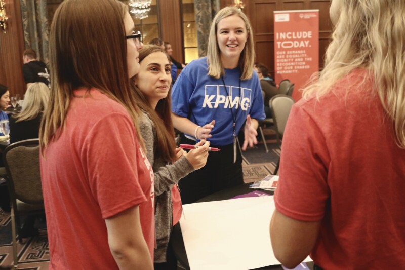 Employee from KPMG engaging in conversation with youth leaders from Special Olympics Canada
