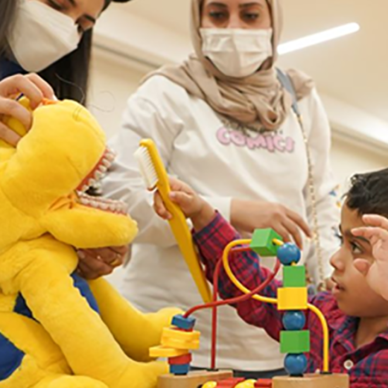Young boy playing with a block toy.