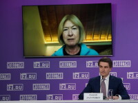 Mary Davis on screen addressing a group of people (out of the image) as a commentator sits and watches. 