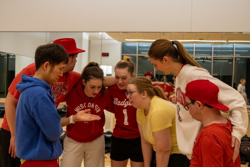 Un grupo de personas se encuentran muy juntas formando un círculo.