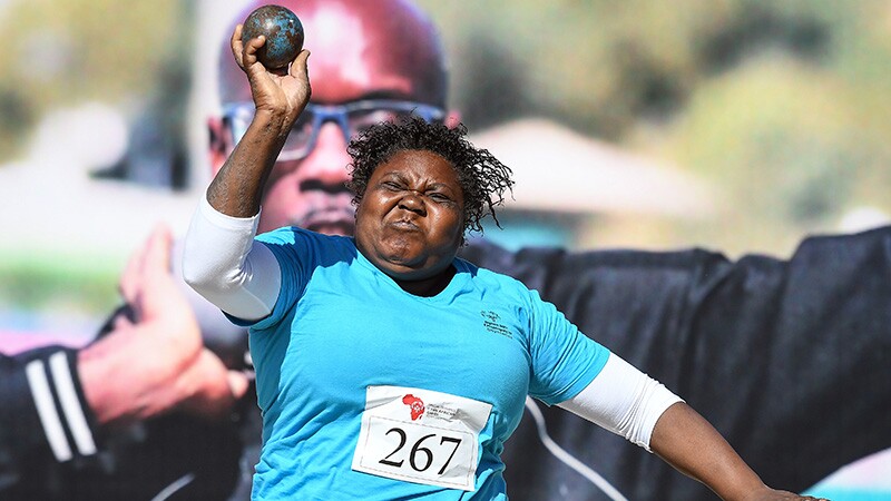 Shot put athlete shot putting on the field.