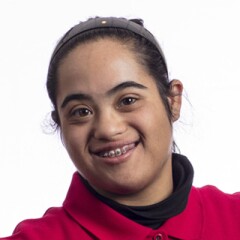 Maryam standing for a professional photo wearing a red long sleeve Special Olympics polo.
