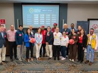 Group of people standing in front of a projected image. 