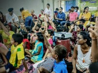 Children in a classroom raising their hands. 