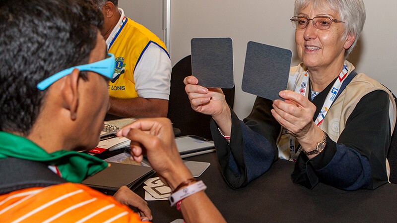Athlete receiving an eye exam by a volunteer.