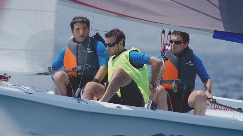 Athlete sailing while his team assists.