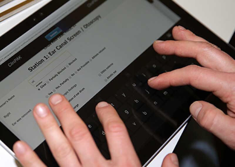 hands typing on a touch screen tablet. 