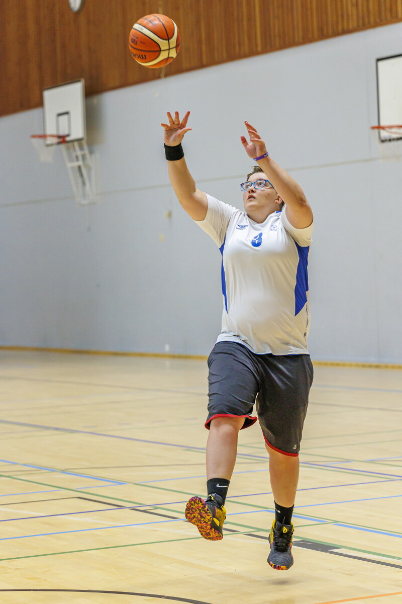 Female basketball player jumping and throwing a basketball