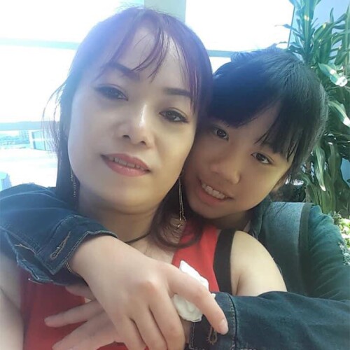 Huang Jou-Fei with her arms around her mother’s next as they smile for a photo together